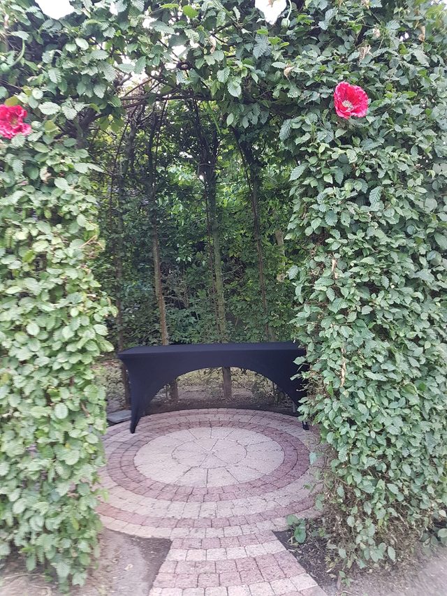 Arche végétale et petit perron fleuri dans le jardin