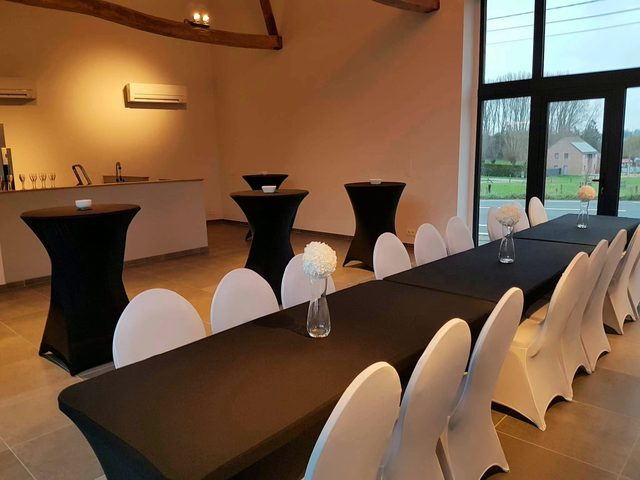 Tables hautes noires et banquet face aux baies vitrées