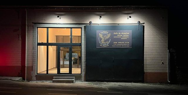 Entrée vitrée éclairée de la salle, le soir